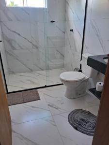 a white bathroom with a shower and a toilet at Pousada casa da amizade in Penha +38 photos