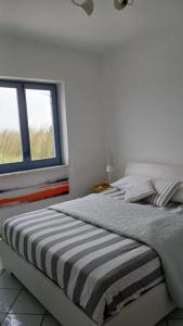 un letto in una stanza bianca con una finestra di Fin Fiori a Menfi