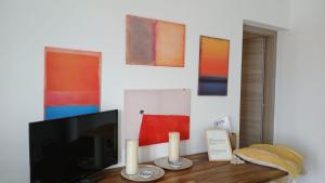 un soggiorno con TV e dipinti alle pareti di Fin Fiori a Menfi