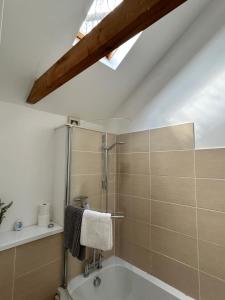 a bathroom with a shower and a bath tub at The Old Stables in Mews in Kessingland