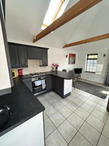 a kitchen with black cabinets and a counter top at The Old Stables in Mews in Kessingland