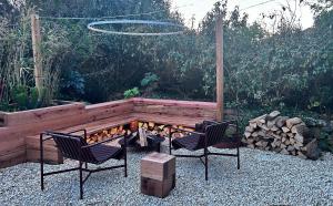 a backyard with two chairs and a fire pit at Howlyek, in St Agnes Village in St. Agnes 
