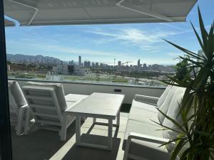 a balcony with a table and chairs and a view of the city at SUNNY home in Finestrat