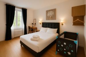 ein Schlafzimmer mit einem Bett mit schwarzem Kopfteil und einem Fenster in der Unterkunft Logis Hôtel du Cirque Troyes centre historique in Troyes