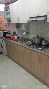 a kitchen counter with pots and pans on a stove at Appart Family Agadir Maskani lhouda in Agadir