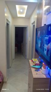 a living room with a flat screen tv on a table at Appart Family Agadir Maskani lhouda in Agadir