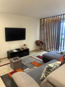 a living room with a couch and a flat screen tv at Casinha da Avenida in Minde