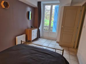 a bedroom with a bed and a dresser and a window at Gîte des sonnailles in Sisteron