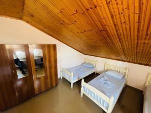 2 camas en una habitación con techo de madera en My Hostel - Privates and Dorms, en Shkodër