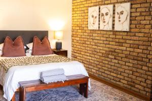a bedroom with a brick wall and a bed at Aan d'Oewer in Citrusdal