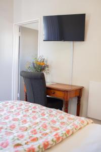 a bedroom with a desk and a table with a bed at Aan d'Oewer in Citrusdal
