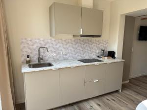 a kitchen with white cabinets and a sink at 't Wieltje in Vlissingen