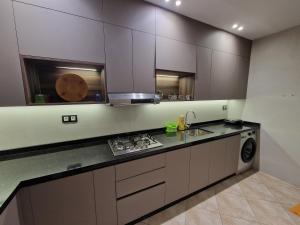 a kitchen with white cabinets and a sink and a stove at Residence Niama C in Tetouan +26 photos