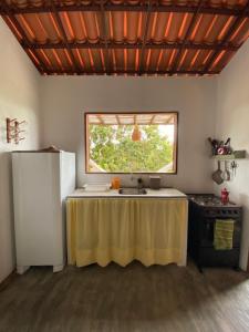a kitchen with a table and a window in it at Chalé Green Vila Mathilde in Icapuí