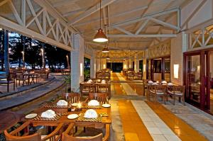 un restaurante con mesas de madera, sillas de madera y registrador en Kura Kura Resort en Karimunjawa