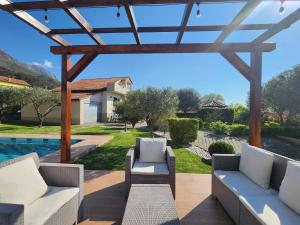 a patio with a pergola and a swimming pool at Kallmet Villa in Kalmet