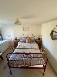 Schlafzimmer mit einem Bett mit Metallrahmen in der Unterkunft Old church cottage in Chulmleigh