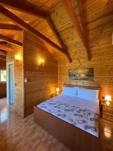 a bedroom with a large bed in a wooden room at The Mussel House in Ksamil
