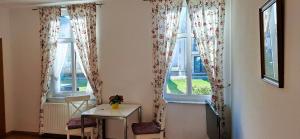 een kamer met 2 ramen met een tafel en stoelen bij Villa Fortuna Gästehaus App Hiddensee in Ahlbeck