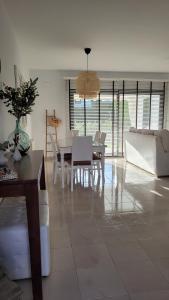 a dining room and living room with a table and chairs at Mi casa playera in El Rompido