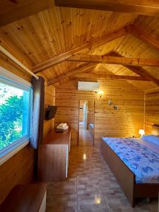 a bedroom with a large bed in a wooden room at The Mussel House in Ksamil