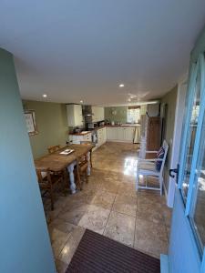 eine Küche und ein Esszimmer mit Tisch und Stühlen in der Unterkunft Old church cottage in Chulmleigh