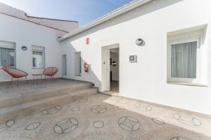 a house with two red chairs on a patio at Apartamentos Turísticos Zibá in Merida