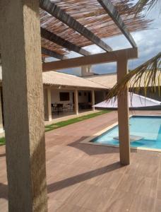 a building with a swimming pool and a patio at Recanto Arubas Aruanä in Aruanã
