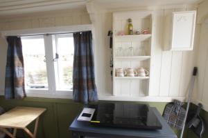 a kitchen with white cabinets and a window at The Cairn Hut in Lybster