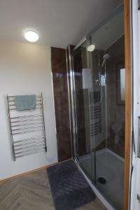 a bathroom with a shower with a glass door at ForbesCroft Huts in Lybster +3 photos