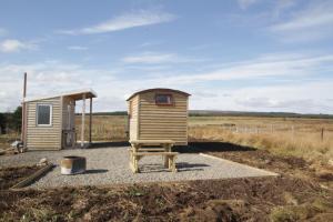 a small shack with a chair in front of it at ForbesCroft Huts in Lybster