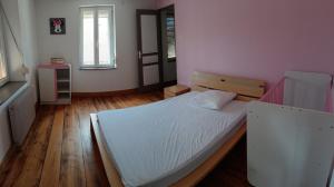 una camera da letto con un grande letto bianco in una stanza di Maison village a Merxheim