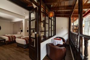 a room with a bedroom with two beds and a couch at Gringo Bill's Boutique Hotel in Machu Picchu +59 photos