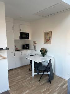 a white kitchen with a white table and a white table at Nybyggd gästlägenhet med sovloft in Falkenberg