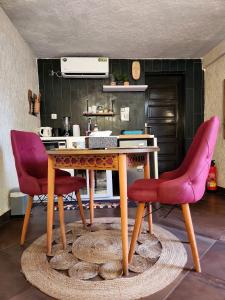 una cucina con tavolo in legno e 2 sedie rosse di Blandine's Little Heaven a Lomé