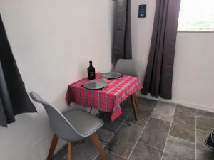 a table with a bottle of wine and two chairs at studio Caraïbes in Les Trois-Îlets