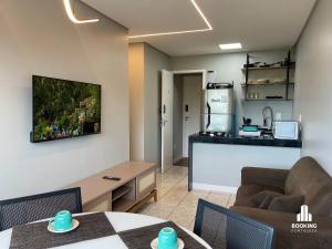 a living room with a couch and a table and a kitchen at River Park Centro de Eventos in Fortaleza