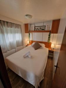 a bedroom with a white bed with two towels on it at Area Parking Caravane in Seville