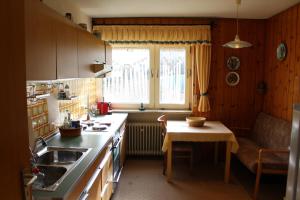 a kitchen with a sink and a table and a window at Elsa's Waldnest-Nähe Fichtelsee in Warmensteinach