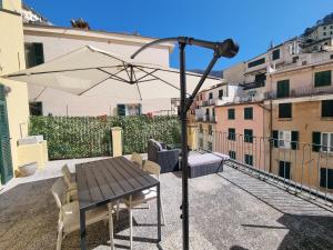 a table with an umbrella on a balcony at Vibes 5terre in Riomaggiore