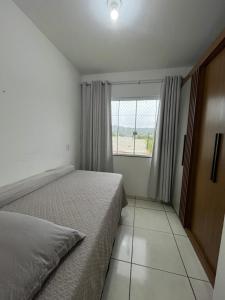 ein kleines Schlafzimmer mit einem Bett und einem Fenster in der Unterkunft Aconchegante Cantinho 202 in Penha