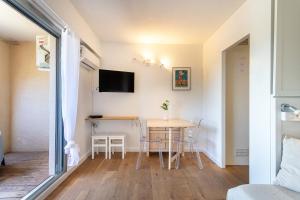 a small apartment with a table and chairs in a room at La Cigale Varoise - Hyères La Plage in Hyères
