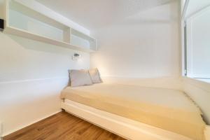 a small bedroom with a bed and a window at La Cigale Varoise - Hyères La Plage in Hyères