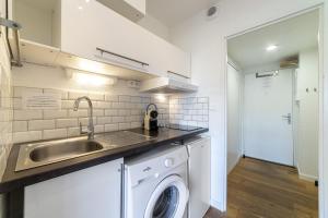 a kitchen with a sink and a washing machine at La Cigale Varoise - Hyères La Plage in Hyères