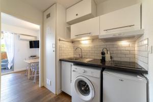 a kitchen with a washer and dryer in a room at La Cigale Varoise - Hyères La Plage in Hyères