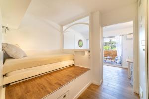 a small bedroom with a bed and a hallway at La Cigale Varoise - Hyères La Plage in Hyères
