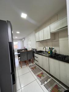 eine Küche mit einem Waschbecken und einem Tisch darin in der Unterkunft Aconchegante Cantinho 202 in Penha