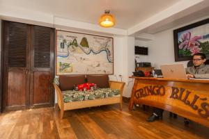 a man sitting at a desk in a room with a laptop at Gringo Bill's Boutique Hotel in Machu Picchu
