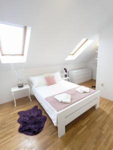 a white bedroom with a bed and a window at House in Gardos in Zemun
