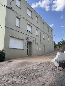 a large gray building with windows on the side of it at Hostal Restaurante el Cazador in Nuévalos